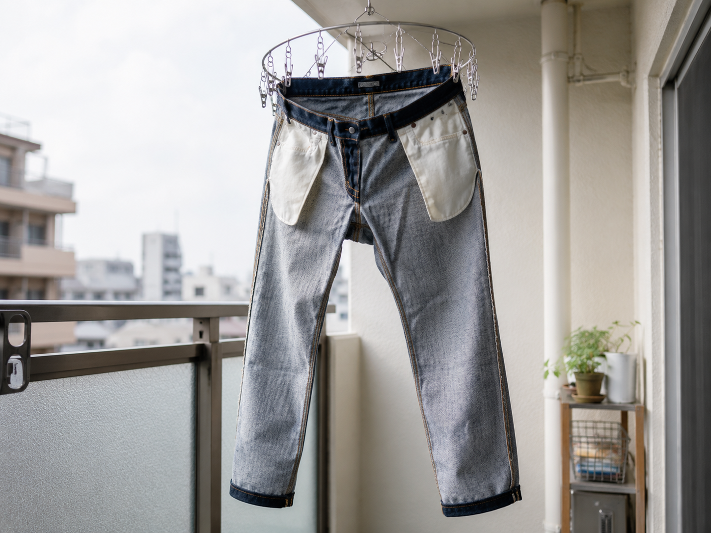 裏返したデニムをピンチハンガーで筒干しにして日陰で乾かしている様子